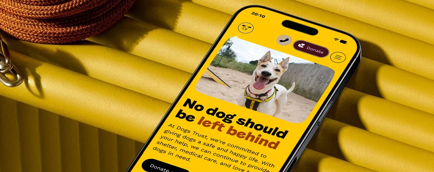 Dogs Trust promotional hero showing website on mobile phone