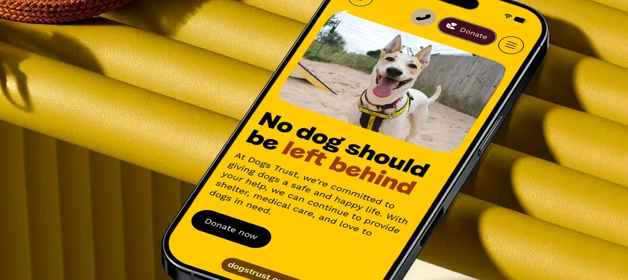 Dogs Trust promotional image with mobile phone displaying the website