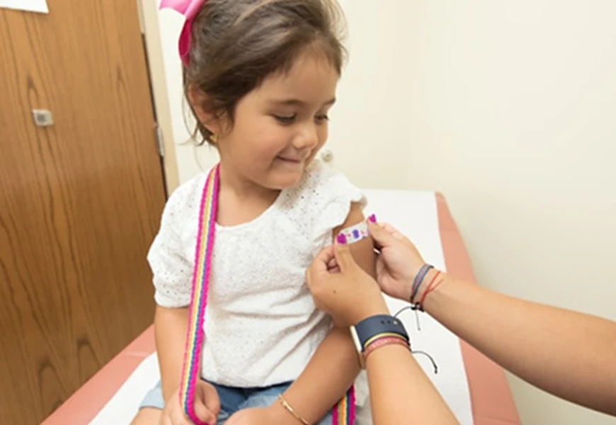 Child being given plaster by nurse