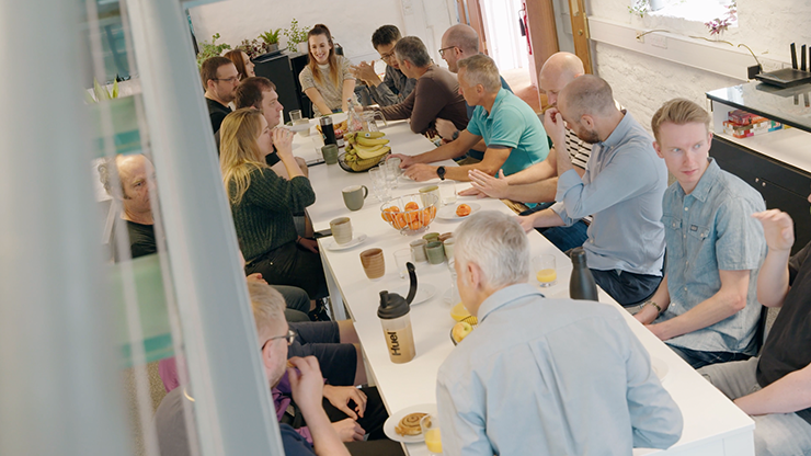 The company sitting down to eat breakfast.